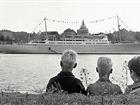 Tre pojkar beskådar kryssningsfartyget Oslofjord som ligger för ankar på Stockholms ström.