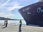 Fören på Mein Schiff 1 samt tre hamnarbetare som förtöjer henne i Frihamnen
