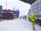 Lastbil rullar av fartyg i ett snöigt Kapellskärs hamn